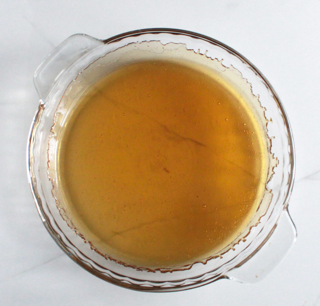 Glass pan showing amber color of caramel